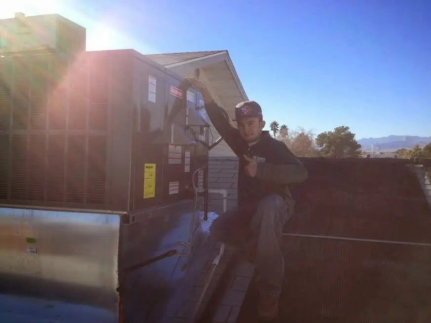 HVAC technician performing HVAC Inspection on a rooftop unit in Hobart